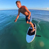 Person standing on a surfboard in clear blue water with 'Insta360 X4' branding.